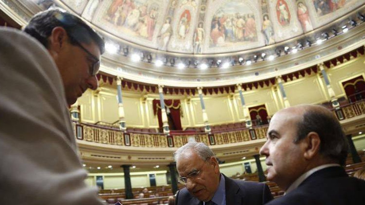 El portavoz de la Izquierda Plural, José Luis Centella, conversa con los diputados socialistas Alfonso Guerra y Gaspar Zarrías.