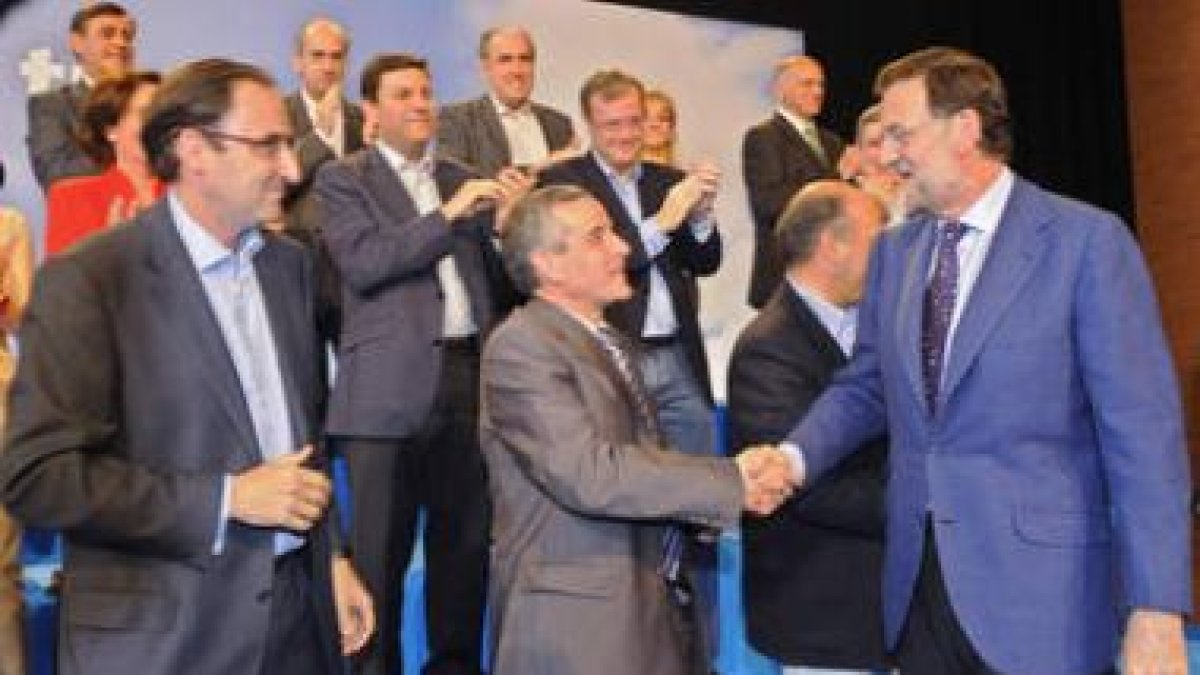 Rajoy saluda a Emilio Gutiérrez en el acto regional del PP en Burgos.