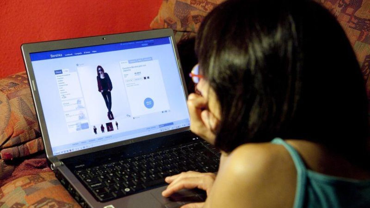 Una joven navega por una página web de ventas on line.