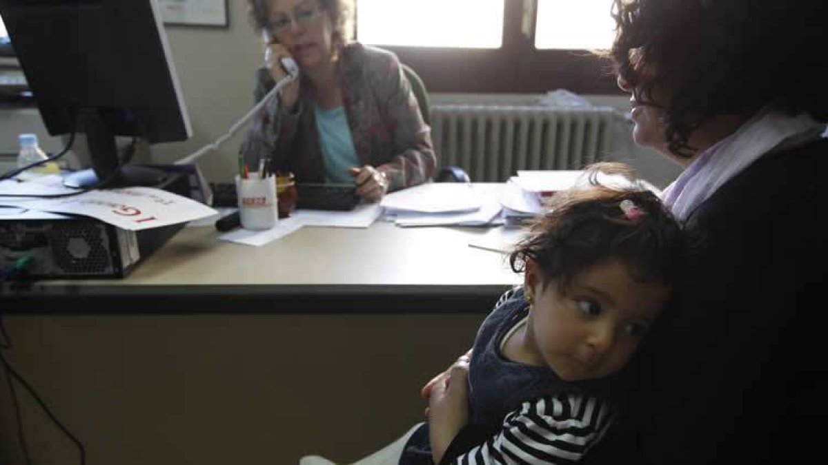 Fatima, con su bebé, pide ayuda a la oficina social de Comisiones Obreras.