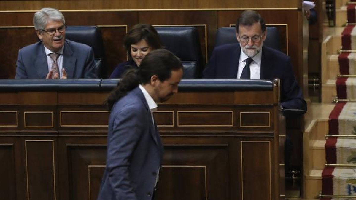 El líder de Podemos, Pablo Iglesias, pasa delante del presidente del Gobierno, Mariano Rajoy