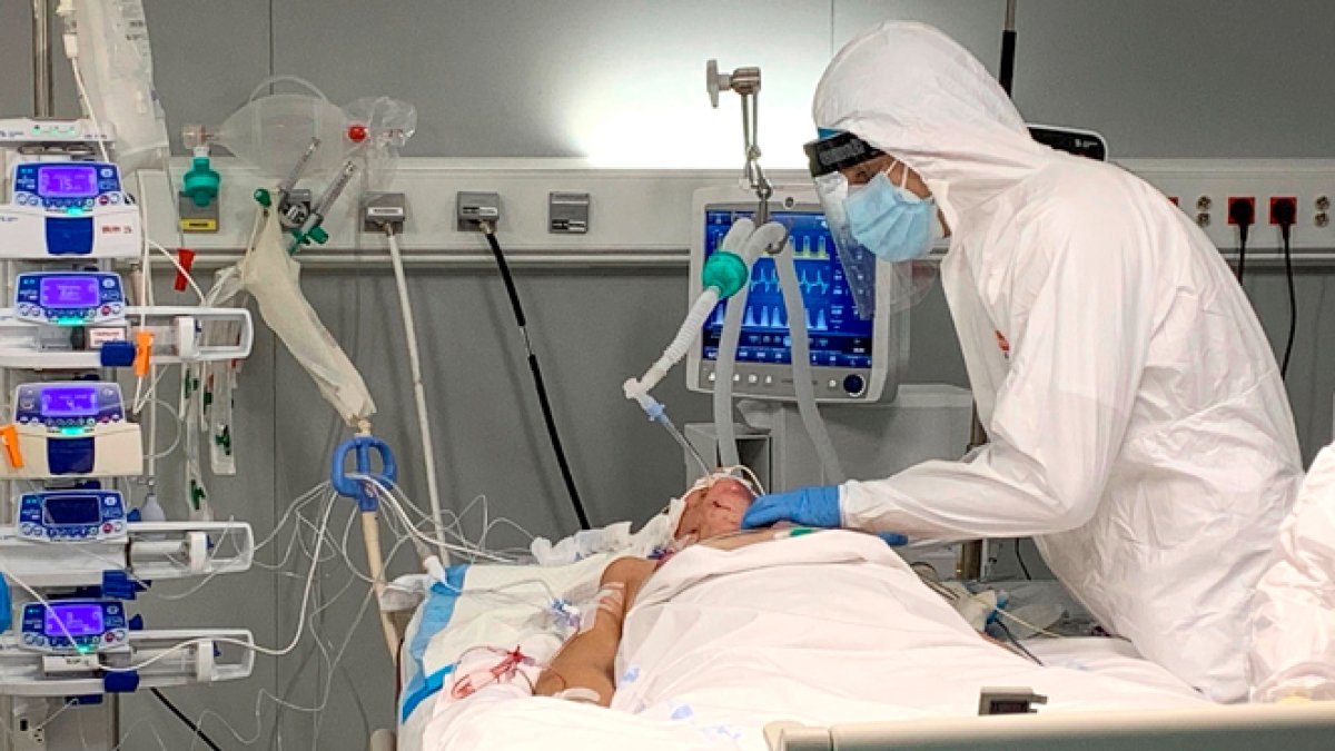 Un trabajador de la sanidad presta cuidados a un enfermo de covid. EFE