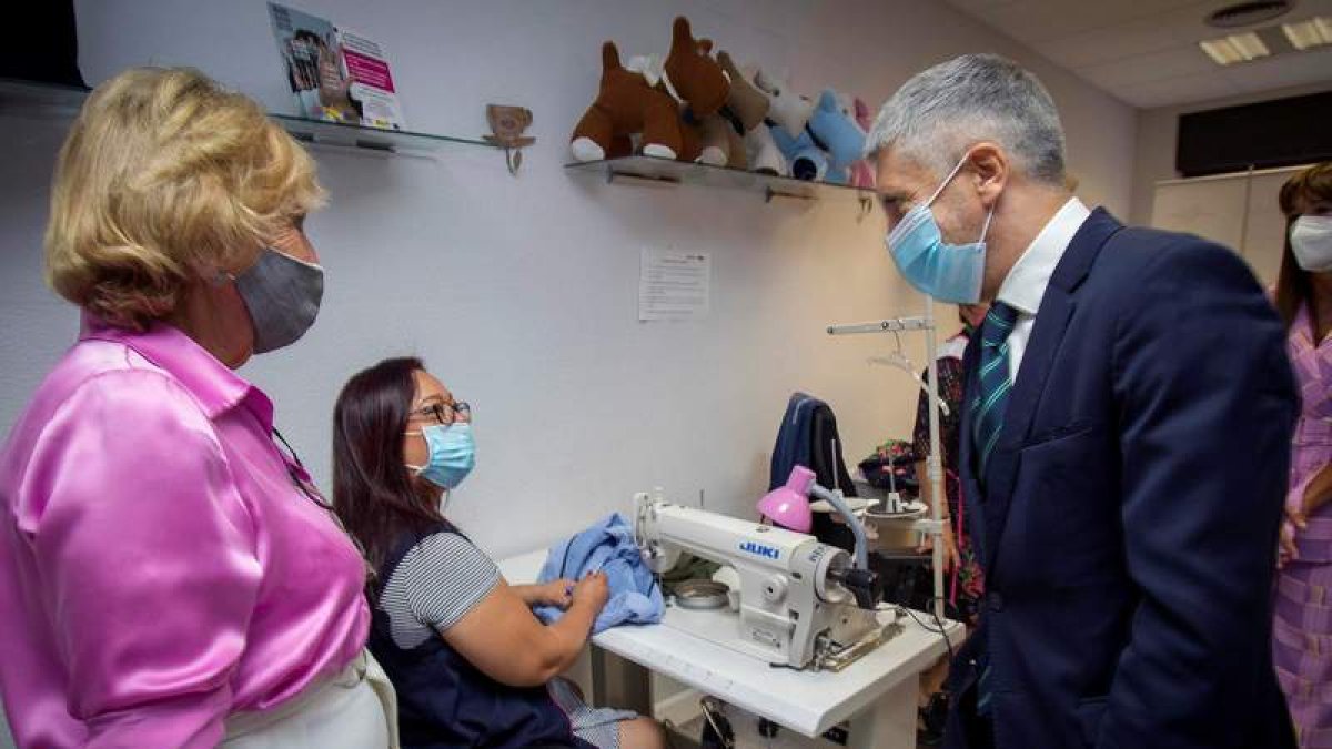 El ministro Grande Marlaska conversa con una mujer del programa de Apramp. MIGUEL BERROCAL