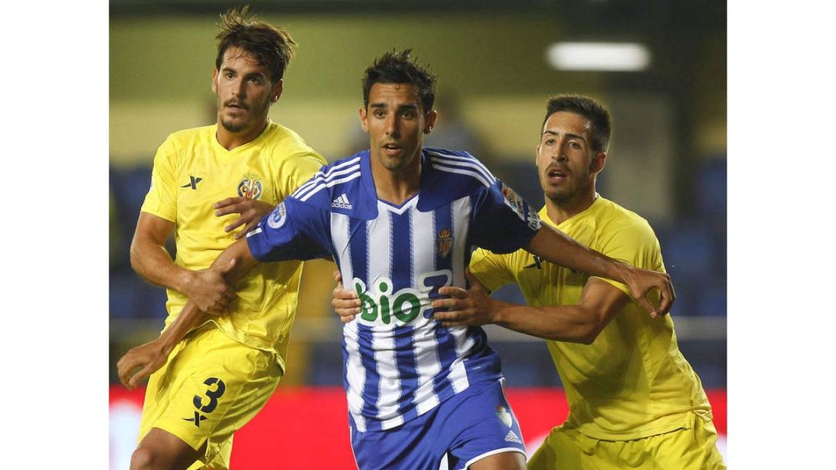 Joan Oriol y Toribio sujetan a Juande en un lance del partido de Copa del Rey disputado en El Madrigal