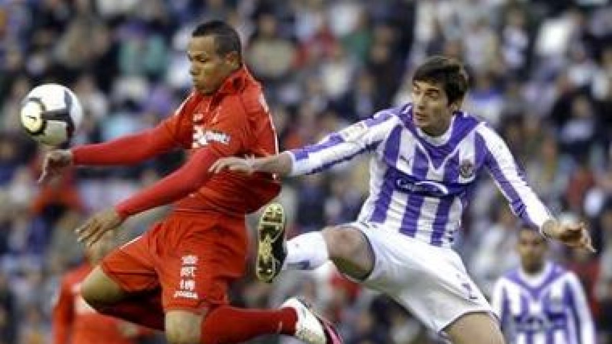 Sereno, a la derecha, pelea un balón con el delantero brasileño del Sevilla Luis Fabiano.