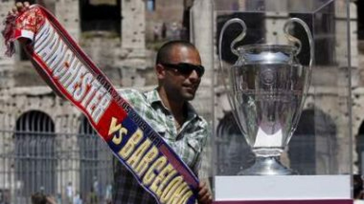 Un seguidor del Barça se hace una foto junto a la copa en el Coliseo