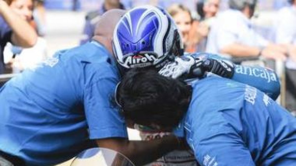 El piloto español Nicolás Terol se abraza a sus compañeros tras ganar en la categoría de 125 cc.
