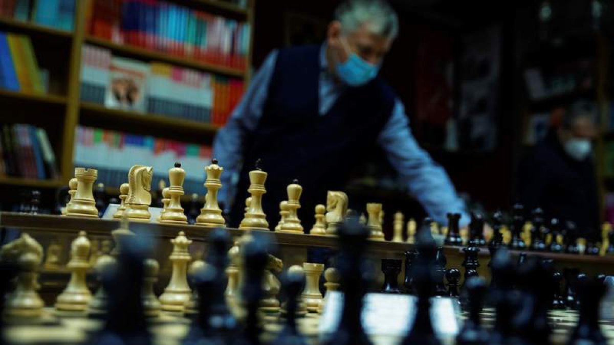 Un empleado coloca las figuras en el tablero en la tienda especializada la casa del ajedrez en Madrid. EMILIO NARANJO