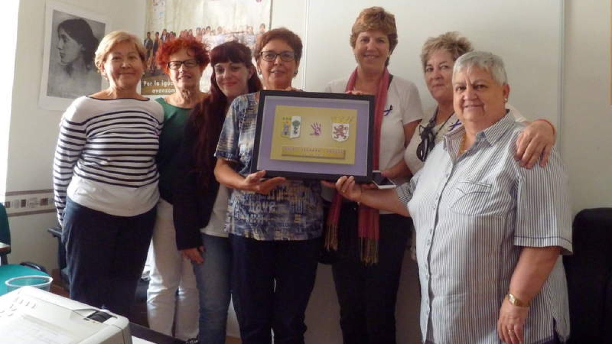 La presidenta de Adavas, Carmen Carlón, muestra el cuadro del hermanamiento obsequio de las mujeres de Karrantza. DL