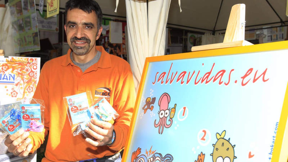 Jesús López sostiene varios packs de las pulseras que vende para conseguir un desfibrilador para el colegio de sus hijos.