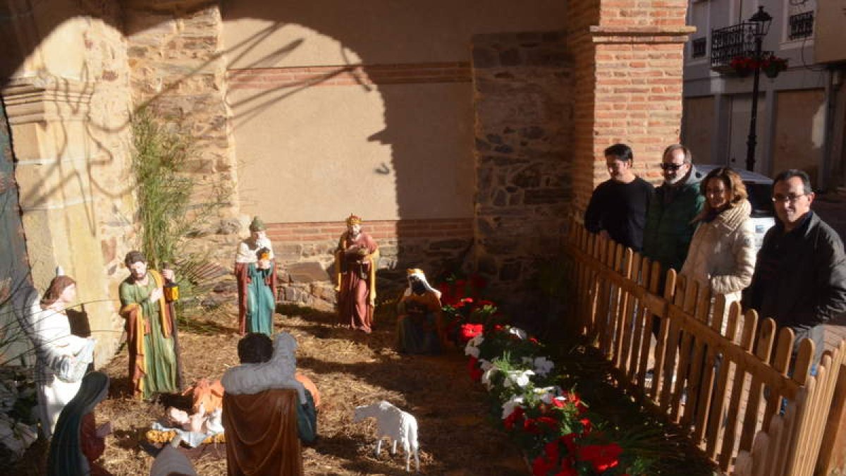 La alcaldesa y otros concejales observan el belén instalado en los soportales de la iglesia. MEDINA