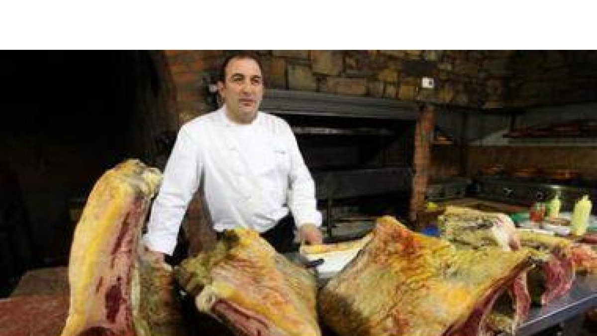 José Gordón, en el asador de su establecimiento, junto a varios costillares de los que ofrece.