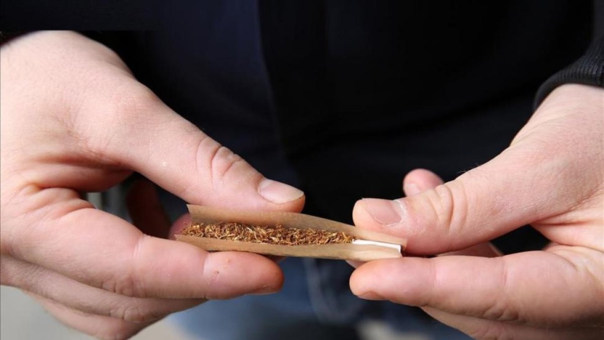 Un joven se prepara un cigarrillo con tabaco de liar.