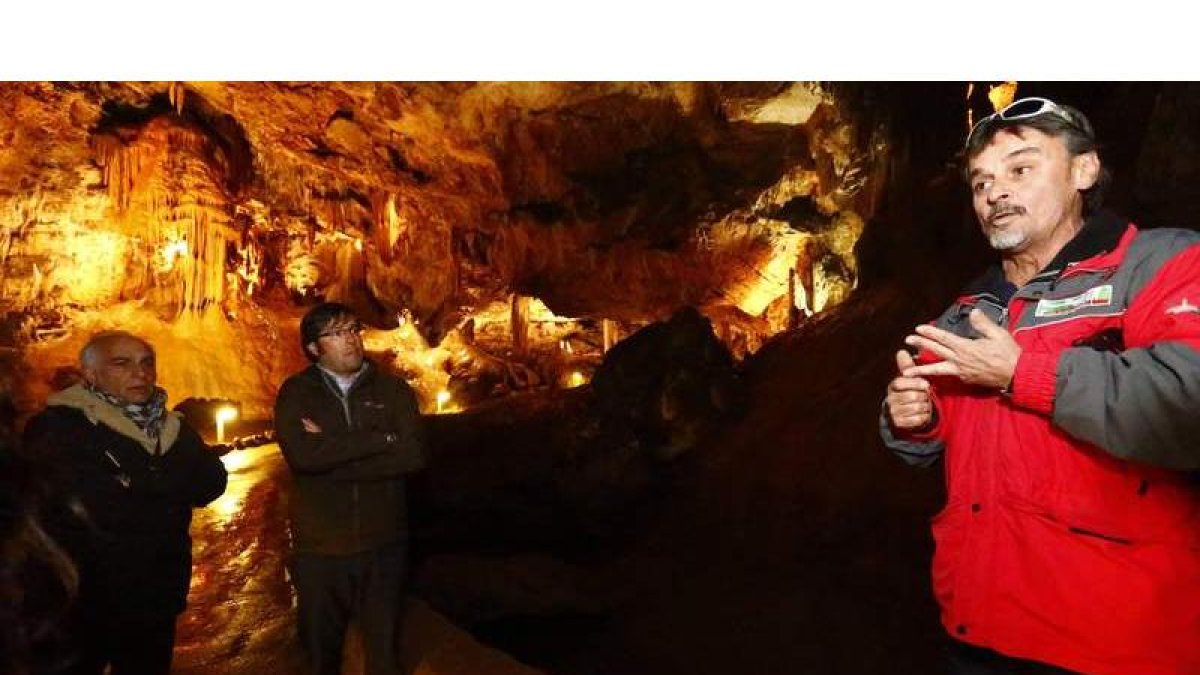 Emilio Orejas y el diputado Miguel Ángel del Egido esuchan las explicaciones de uno de los guías de la cueva.