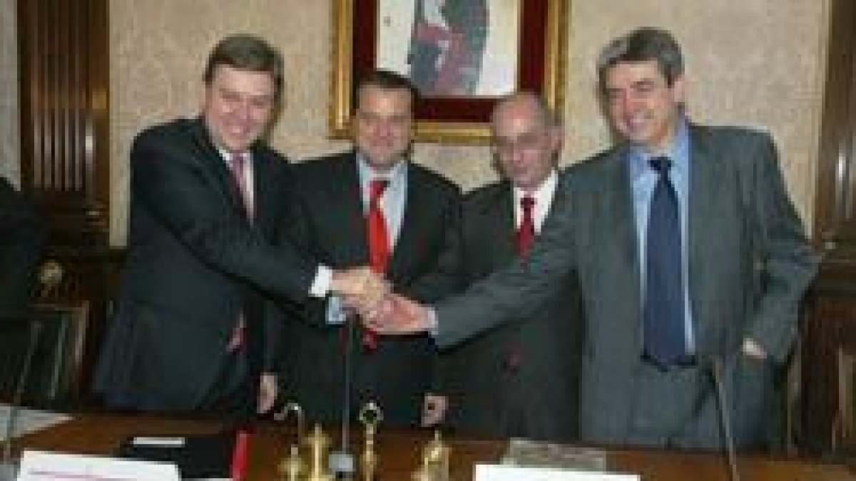 Los protagonistas del acuerdo juntan sus manos tras la firma