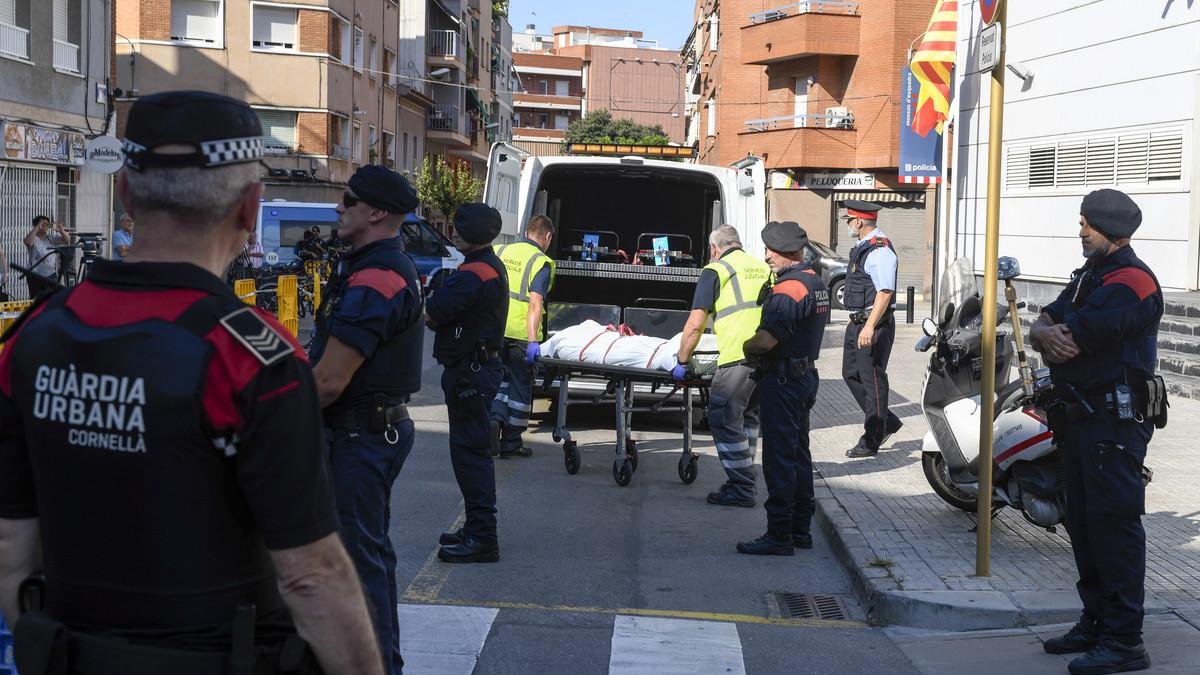 Miembros de la funeraria judicial retiran el cadáver del agresor de la comisaría de los Mossos en Cornellà. /