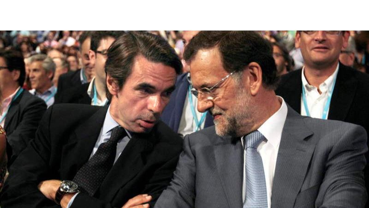 El expresidente del Gobierno, José María Aznar, conversa con el candidato del PP, Mariano Rajoy, durante la convención.