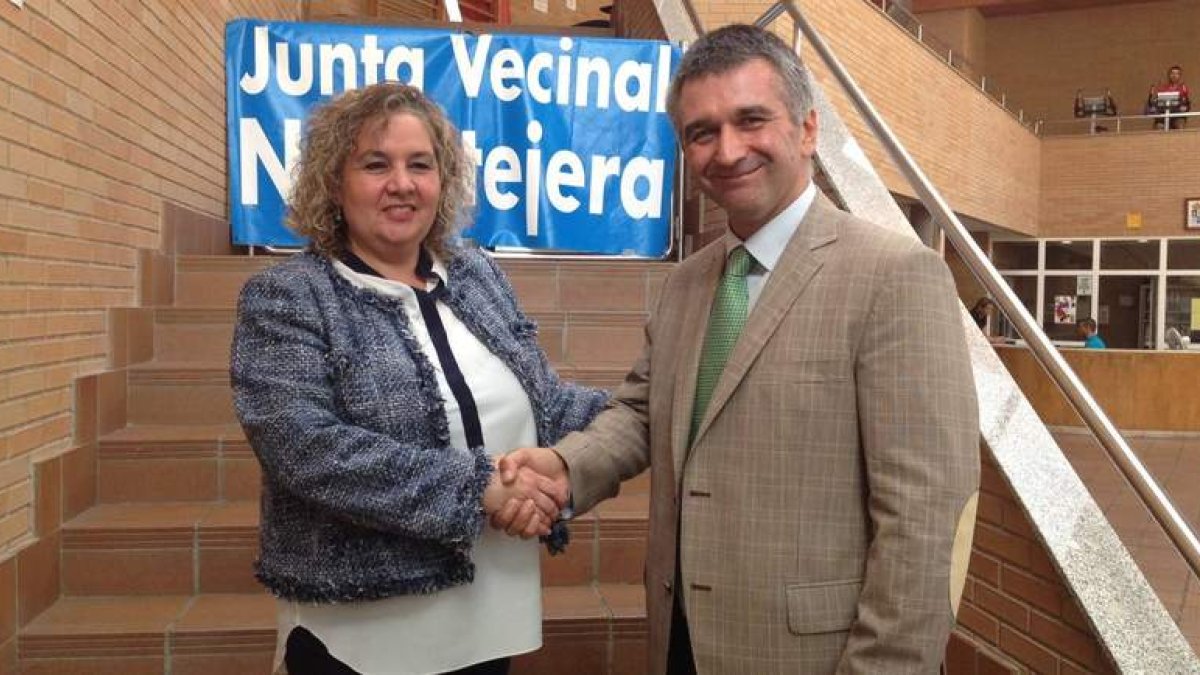 La presidenta de la Junta Vecinal y el vicerrector de estudiantes, estrechándose las manos.