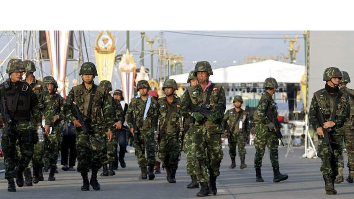 Varios soldados tailandeses avanzan a dispersar un acto de los ‘camisas rojas’ progubernamentales a las afueras de Bangkok.