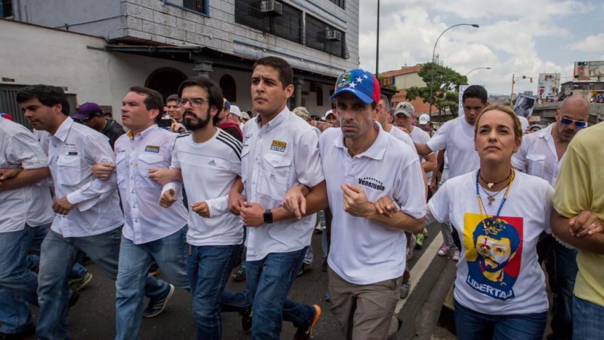 El líder opositor Henrique Capriles (segundo por la derecha) y la esposa del líder opositor Leopoldo López, Lilian Tintori, participan en una manifestación contra el gobierno nacional.