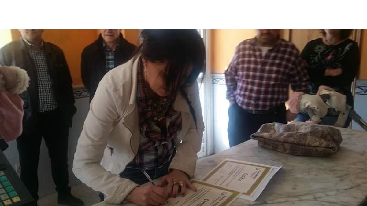 La madre de la niña, Sara Álvarez, firmando el diploma.