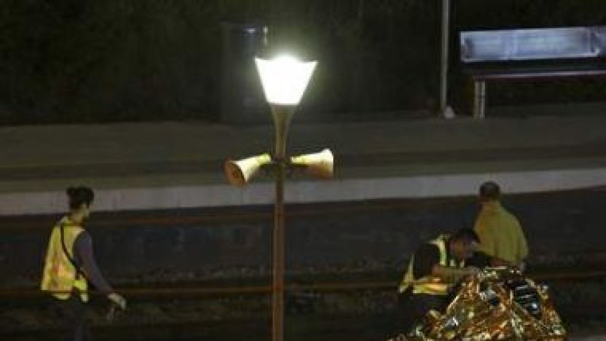 Agentes de la policía científica examinan los restos mortales de una de las víctimas.