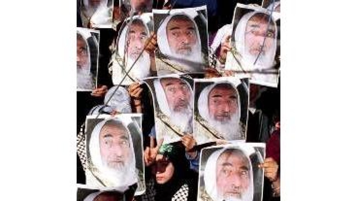 Una niña palestina hace la señal de victoria entre pancartas de Yasím