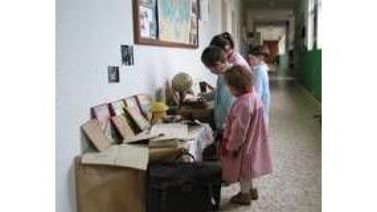 Unos niños observan la exposición de homenaje a la escuela rural en San Justo