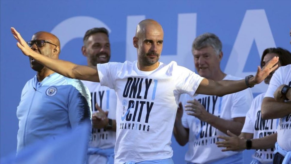 Guardiola festeja su primera Premier por las calles de Manchester.