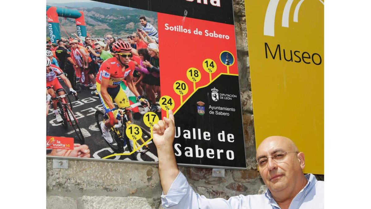 Ángel Colin delante de un cartel de la Vuelta a España ubicado en Sabero que anuncia la ascensión a La Camperona. SECUNDINO PÉREZ