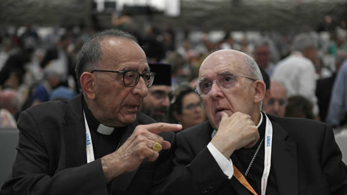 El presidente de la Conferencia Episcopal, el cardenal Juan José Omella, conversa con el arzobispo de Madrid, Carlos Osoro (d), durante la presentación de la síntesis de las propuestas recibidas en la fase diocesana del Sínodo en la que han participado 215.000 personas -laicos y religiosos- con aportaciones que plantean, entre otras medidas, abrir el debate sobre el celibato opcional o el sacerdocio femenino.. VÍCTOR LERENA