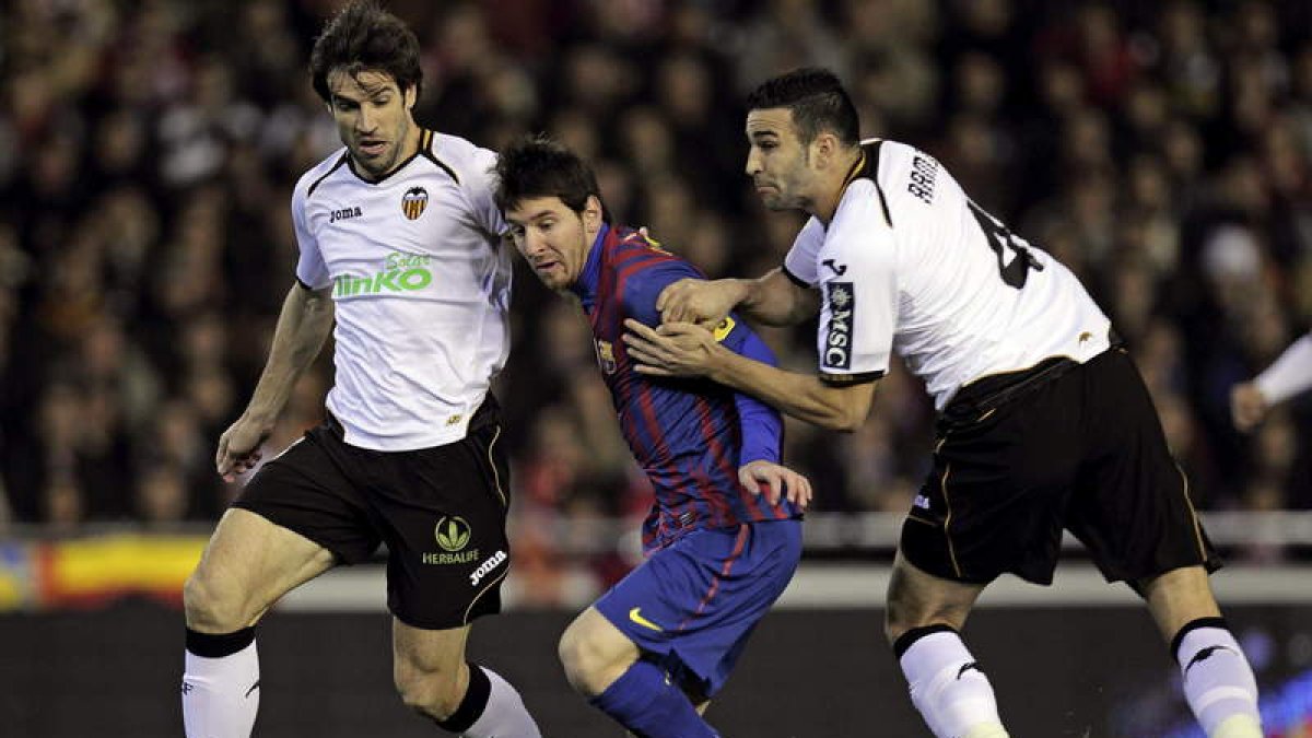 Messi intenta superar a los jugadores del Valencia Albelda y Rami. El argentino estuvo poco acertado ante la portería rival.