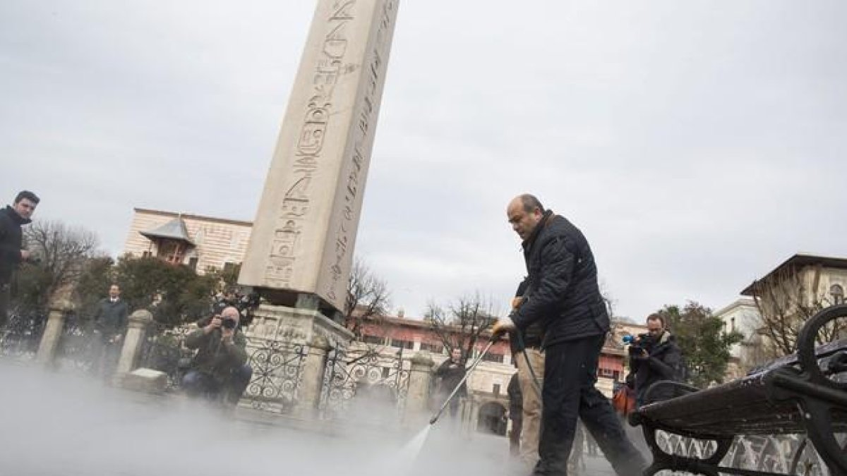 Un operario limpia el escenario del atentado suicida de ayer junto a uno de los obeliscos que se alzan en la explanada de Sultanahmet.