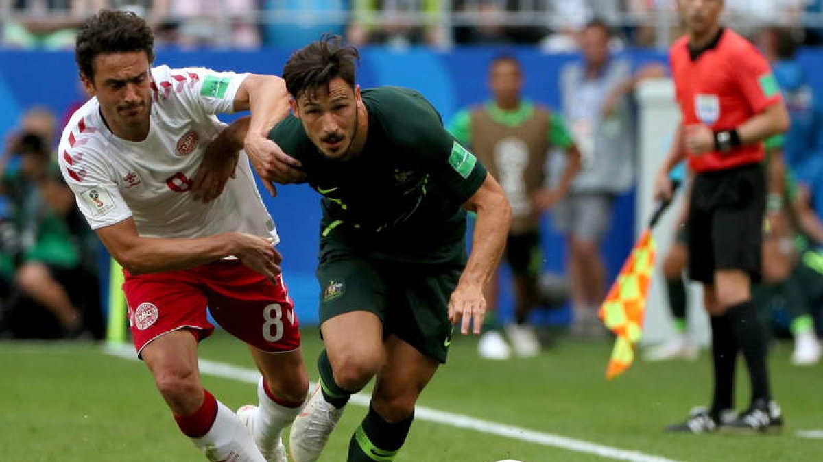 Delaney lucha por el control del balón con Mathew Leckie. WALLACE WOON