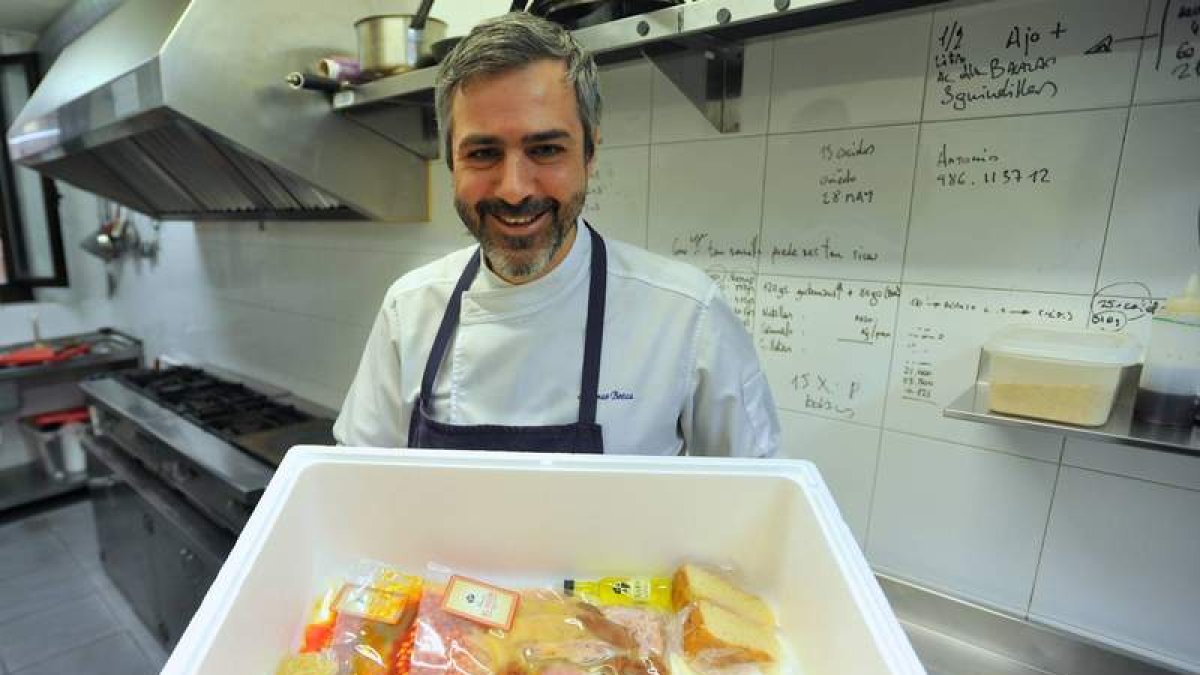 Alfonso Botas muestra la caja que envía con el cocido preparado y envasado al vacío.