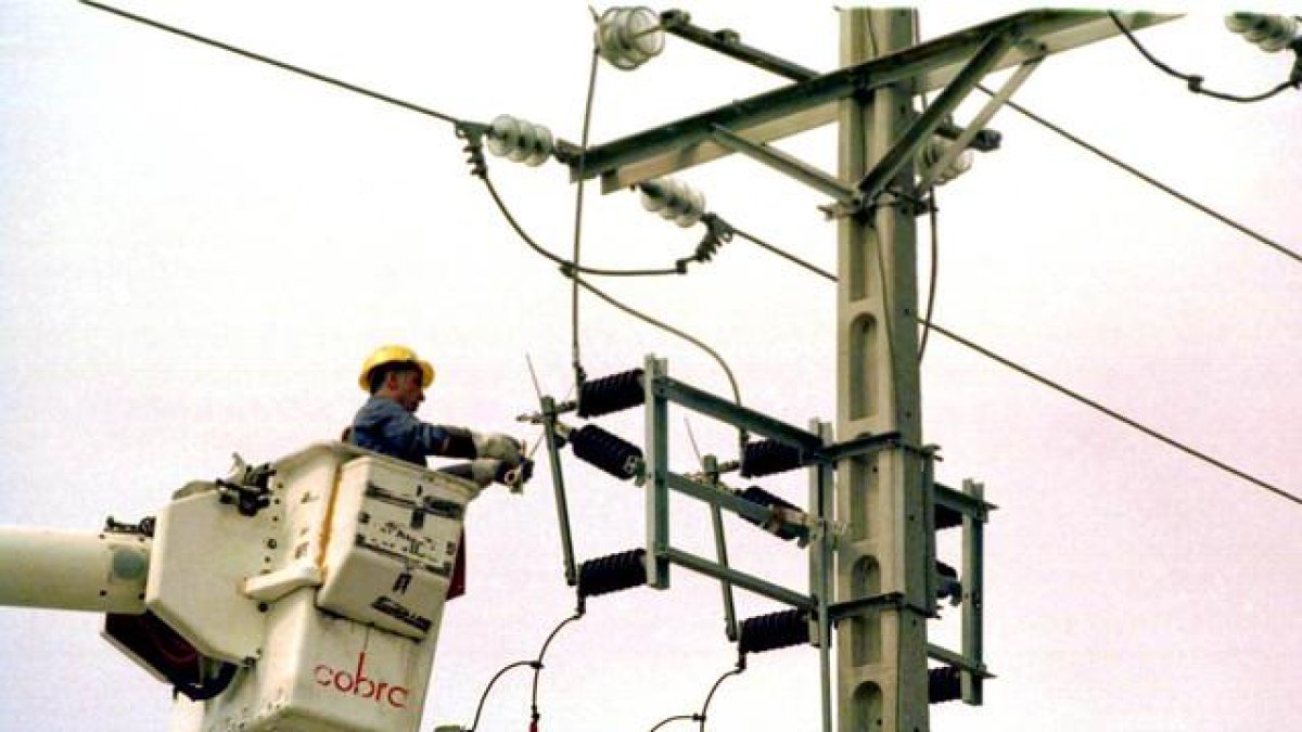Un equipo técnico repara un poste de electricidad.