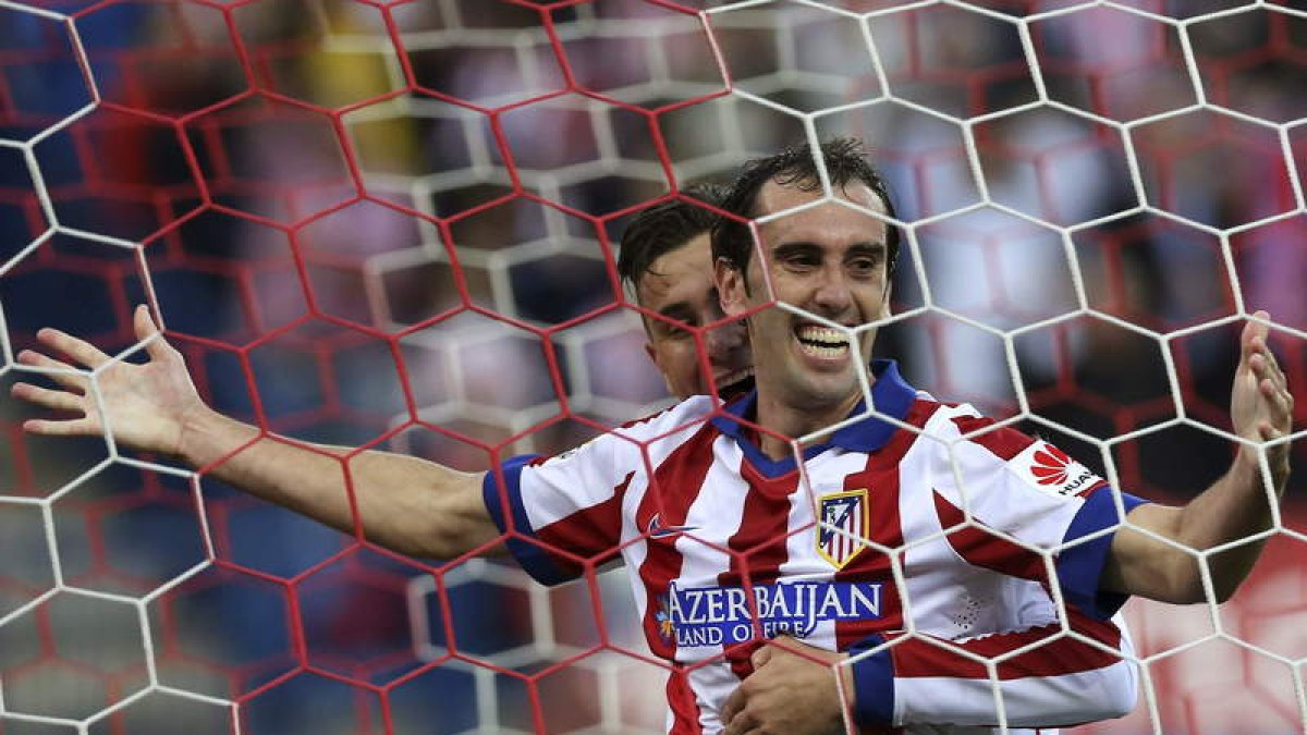 Godin, en primer término, celebra el gol, tercero del Atlético de Madrid ante al Málaga