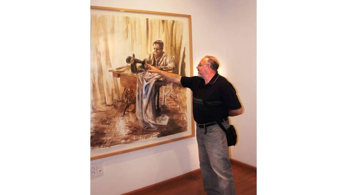 Isacio de la Fuente señala uno de los cuadros de su exposición. «Esa vieja máquina «Singer» tiene una gran importancia plástica en mis recuerdos».