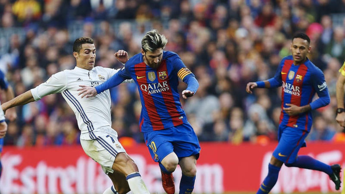 Cristiano y Messi luchan por el balón durante el último clásico entre Madrid y Barça. ALEJANDRO GARCÍA