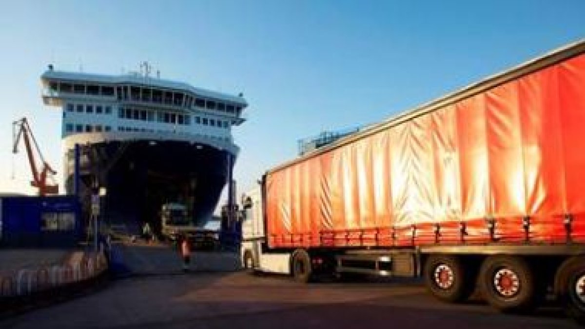 Dos camiones acceden al barco en el puerto del Musel de Gijón.