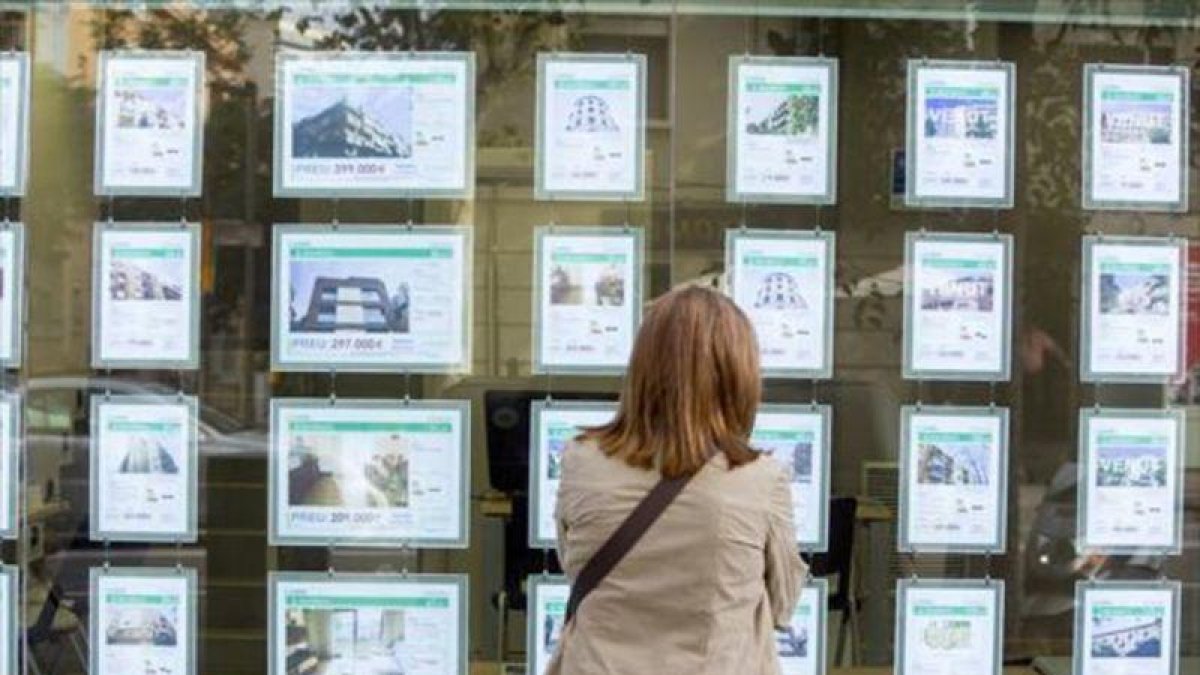 Una mujer mira ofertas de compra y alquiler de viviendas.