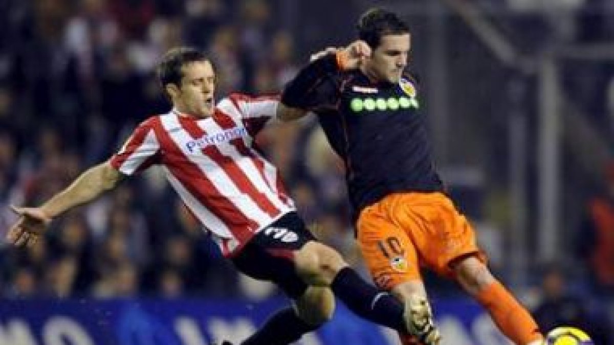 El defensa del Athlétic, Koikili Lertxundi, disputa un balón con el delantero del Valencia, Mata.