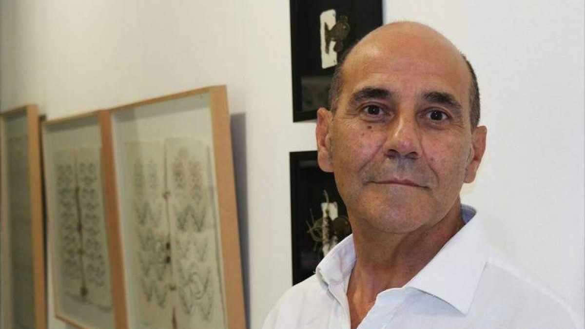 Miguel Escanciano junto a sus obras en una exposición. CUEVAS