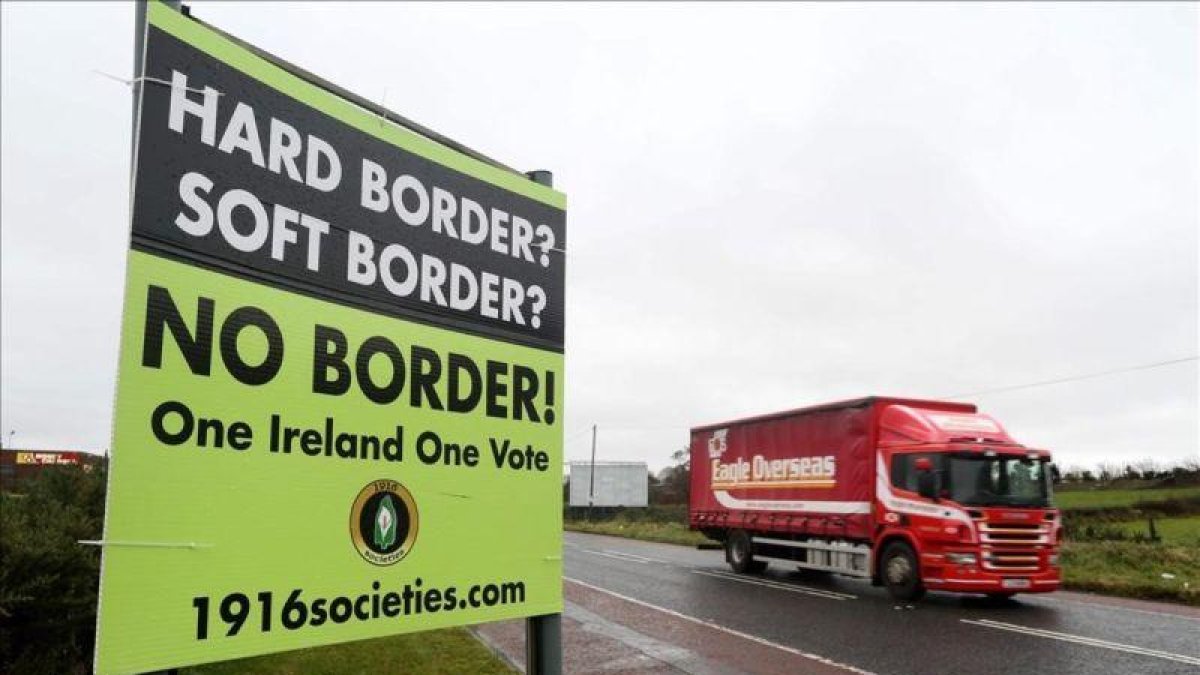 Un automóvil circula junto a un cartel que reclama que no haya frontera entre Irlanda e Irlanda del Norte.
