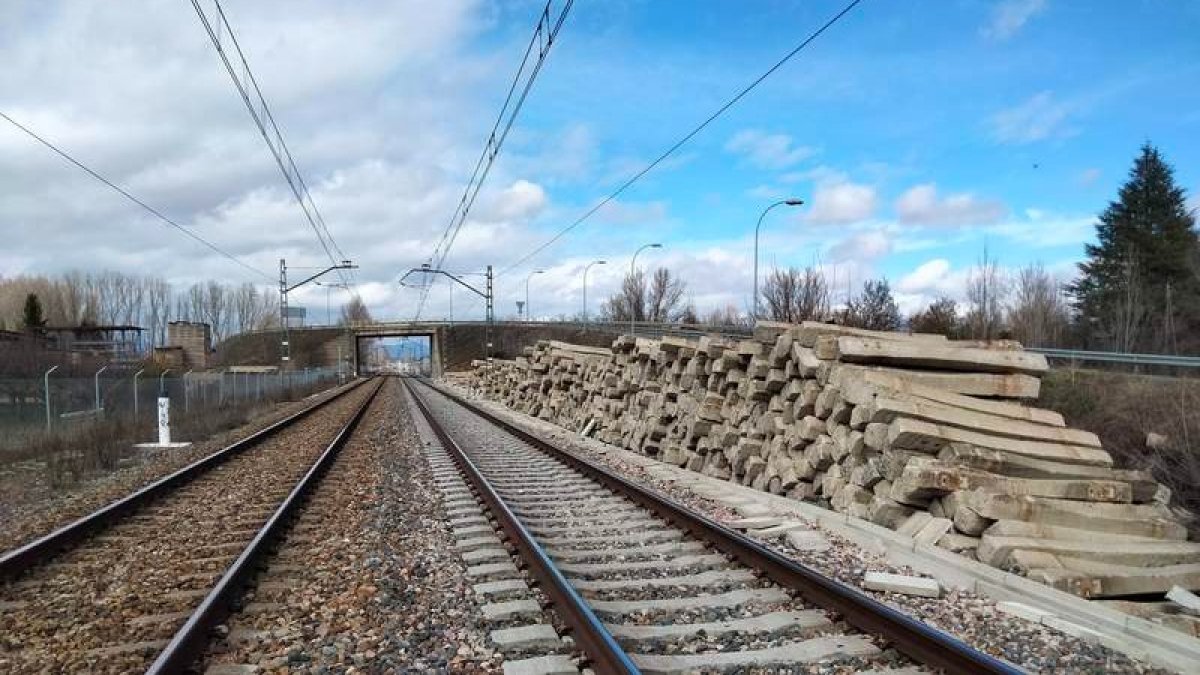 Imagen de un tramo entre León-La Robla, con una vía renovada y traviesas sobrantes apiladas. DL