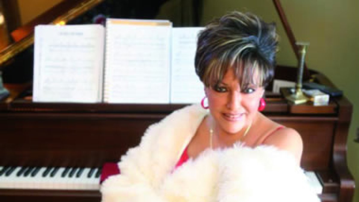 Malena Burke, junto al piano que le acompaña en muchas de sus melodías.