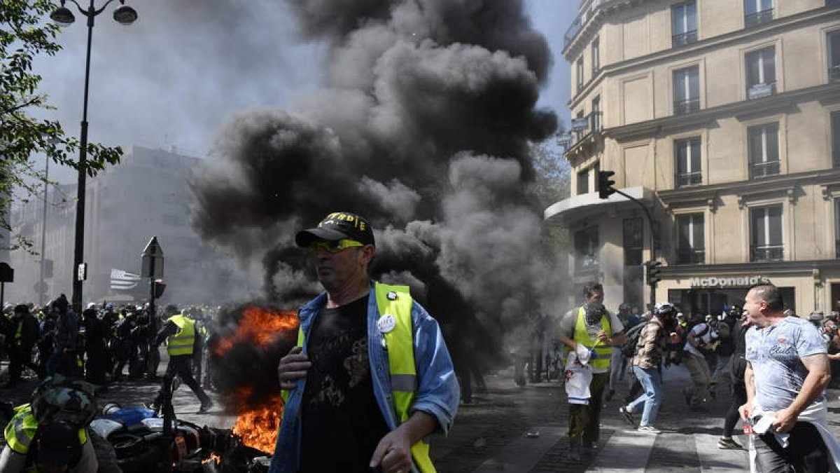 Quema de vehículos y destrozo de material urbano durante la protesta en París. DE ROSA