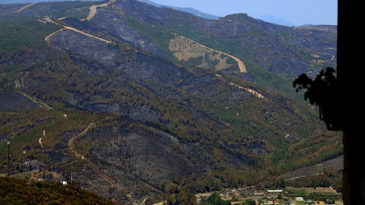 Vista de la zona quemada en la vertiente gallega desde la localidad berciana de San Pedro de Trones, en una imagen tomada ayer a primera hora de la tarde. ANA F. BARREDO