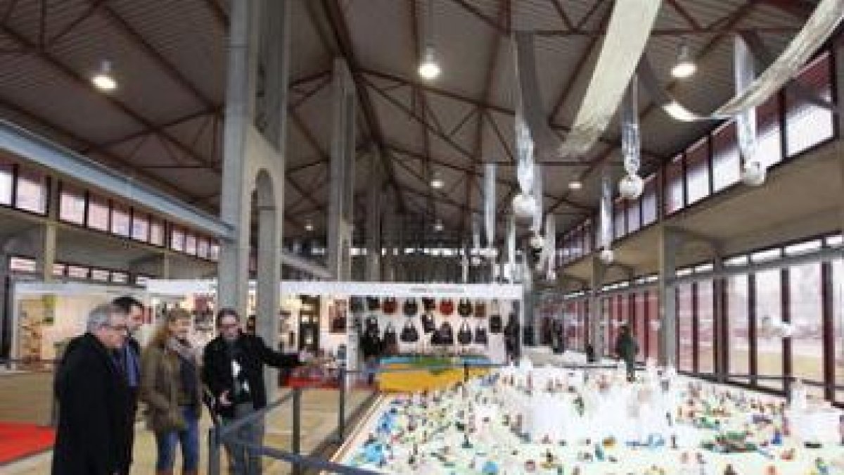 El presidente de la asociación de artesanos enseña el belén de plastilina a las autoridades.