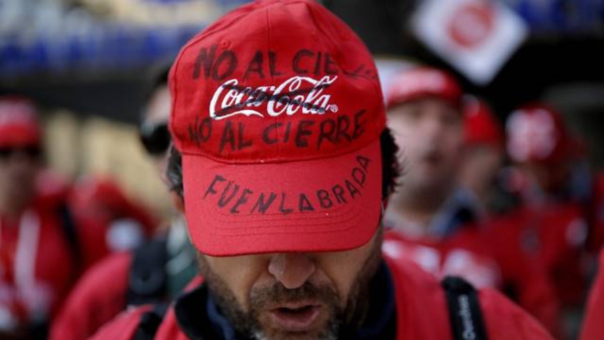 Trabajadores de Coca Cola protestan por el cierre de fábricas, frente a la sede del Partido Popular.